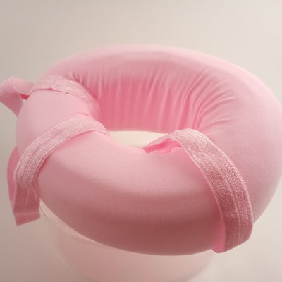Pink foam donut pillow with a hole for sore ear.