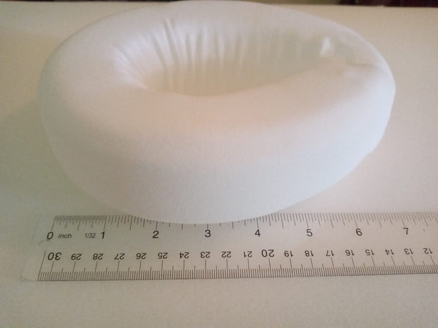 This is a 5 by 7 inch foam donut about 2 inches thick, comes with an elastic strap for the waist. The center hole is 3 by 2 inches and protects a stoma from the pressure of a seat belt.